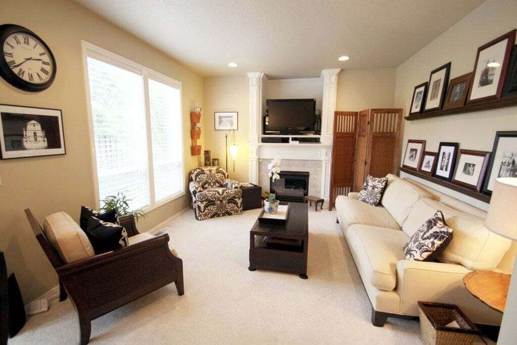 Family room after with picture shelves cream colored walls couch with chairs