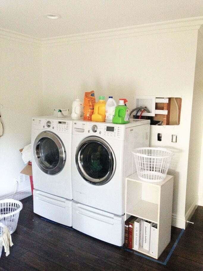 white LG washer and dryer on pedestal drawer stands, laundry room unfinished