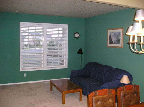 Living room before with teal walls and blue couch