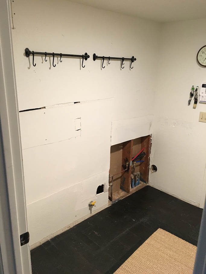 emptied old laundry room with hooks on wall