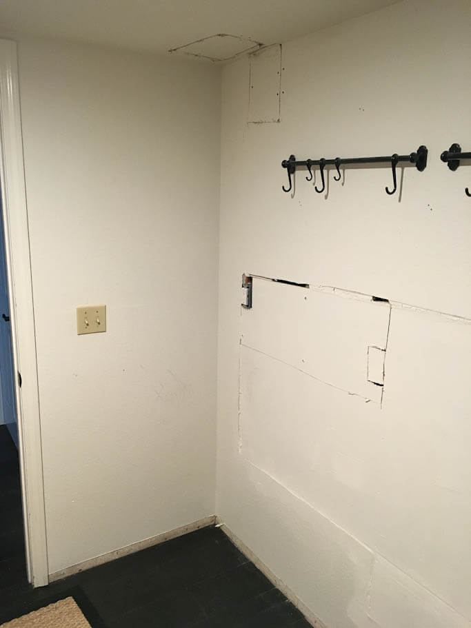 empty old laundry room with rod and hooks on wall