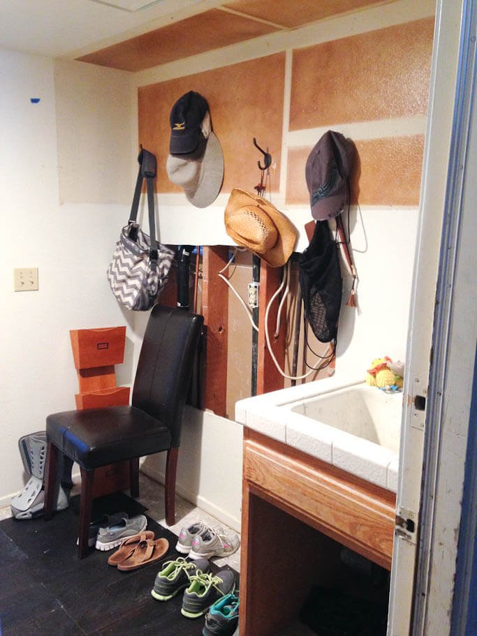 mudroom in transition, chair, shoes on floor, sink in corner, hooks on wall