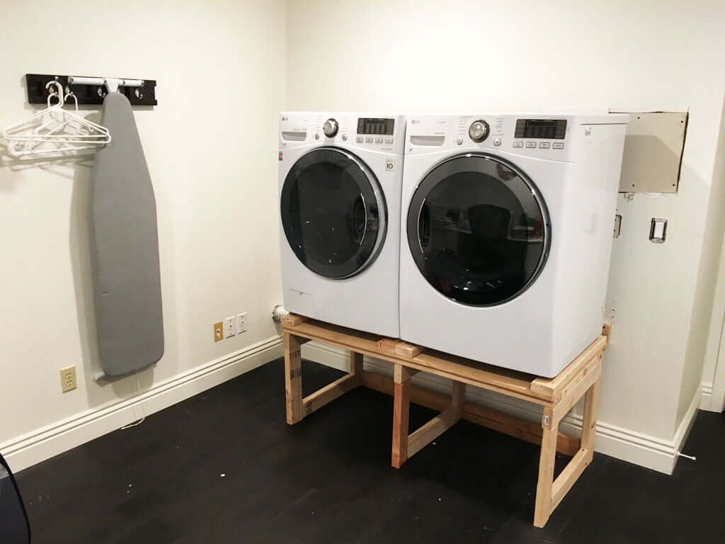 raised washer and dryer on rough wood temporary stand