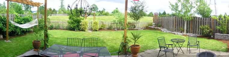 Backyard view with lawn and patio seating areas