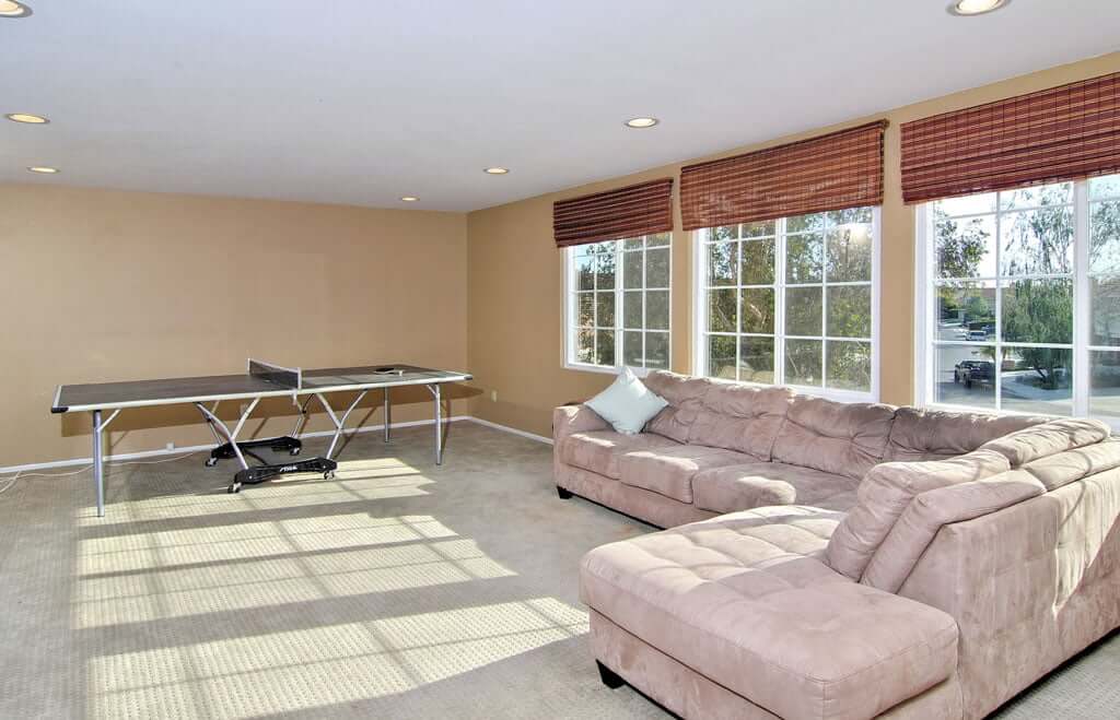 bonus room with couch and ping pong table