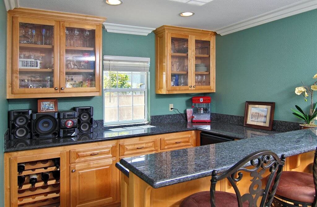 bar area with cabinets and granite counterop