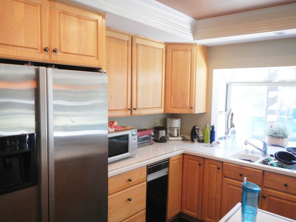 kitchen wall with refrigerator and cabinets