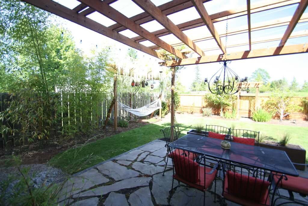 Backyard showing dining set with arbor and hammock arbor, bamboo, wisteria