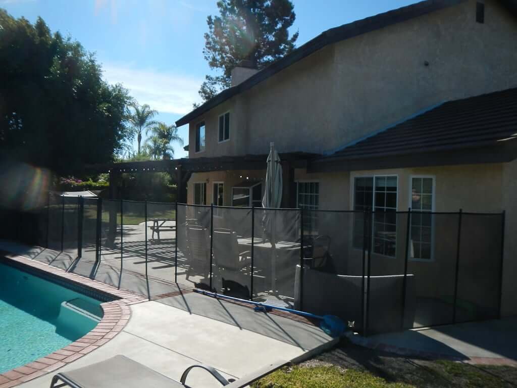 back of house showing removable pool fence and arbor