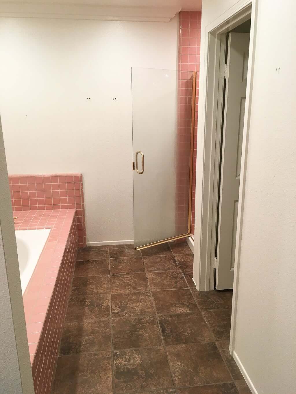 bathroom remodel before pic with pink tile and brown floor