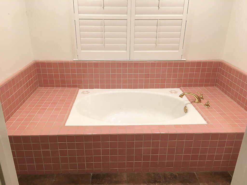 bathroom tub with pink tile surround