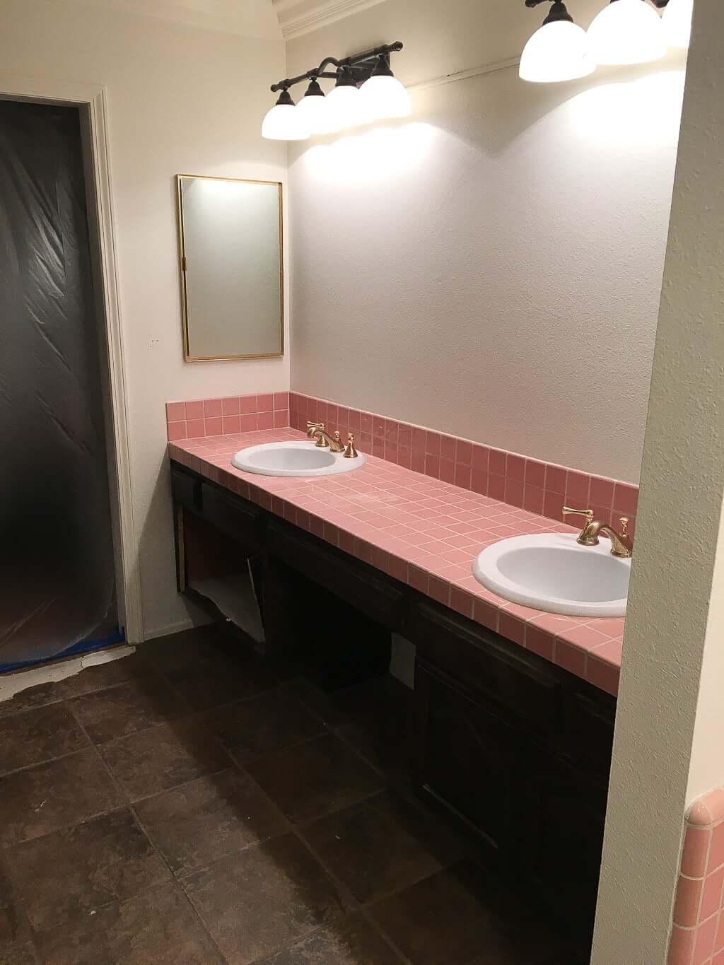 bathroom vanity with pink tile counter and dark tile floors