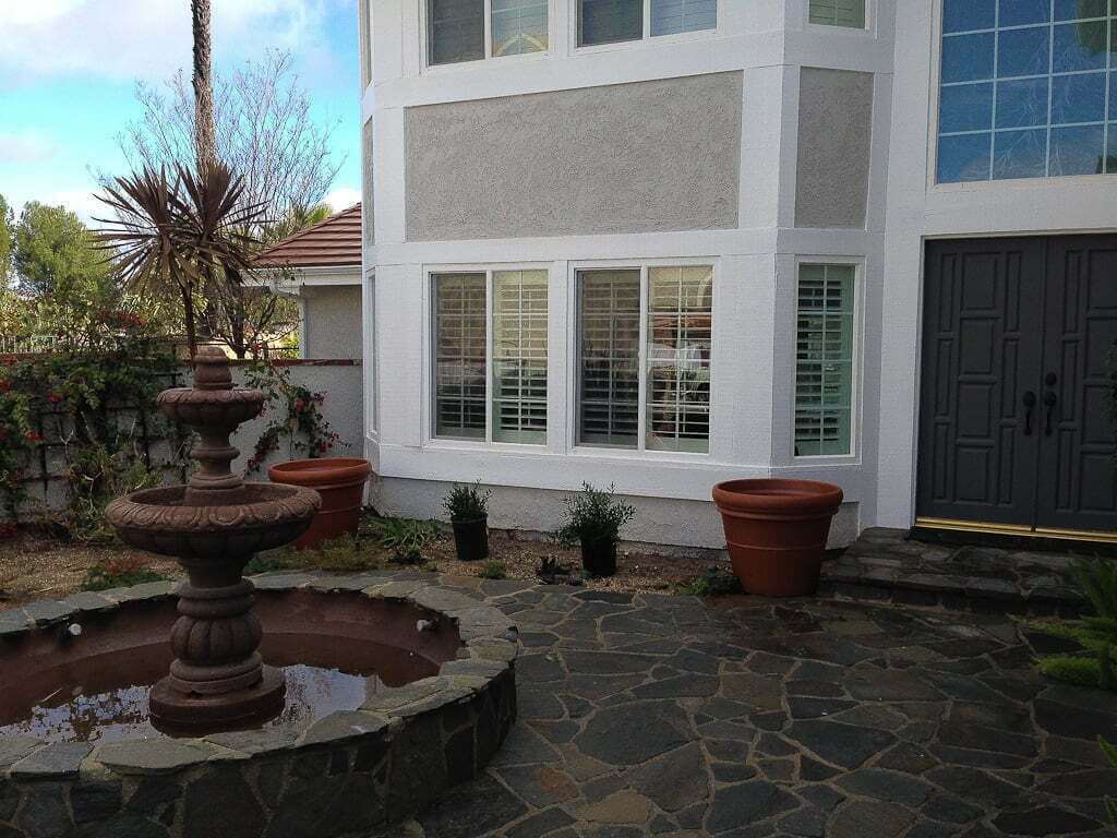 courtyard landscaped entry to house with fountain in middle