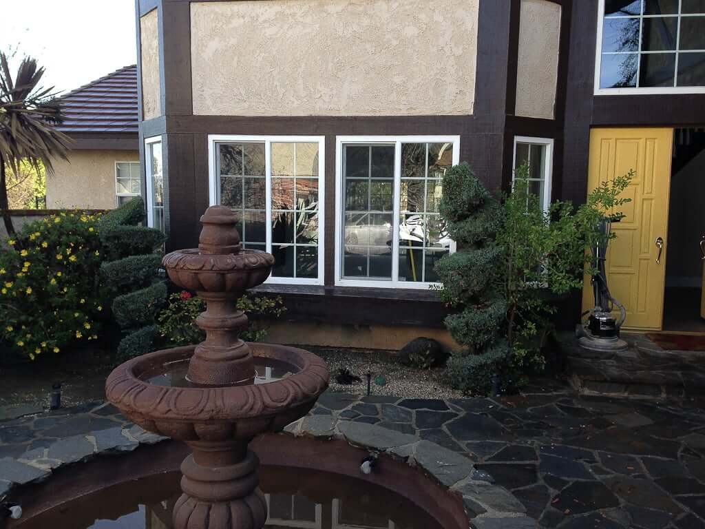 round tiered fountain in front of house