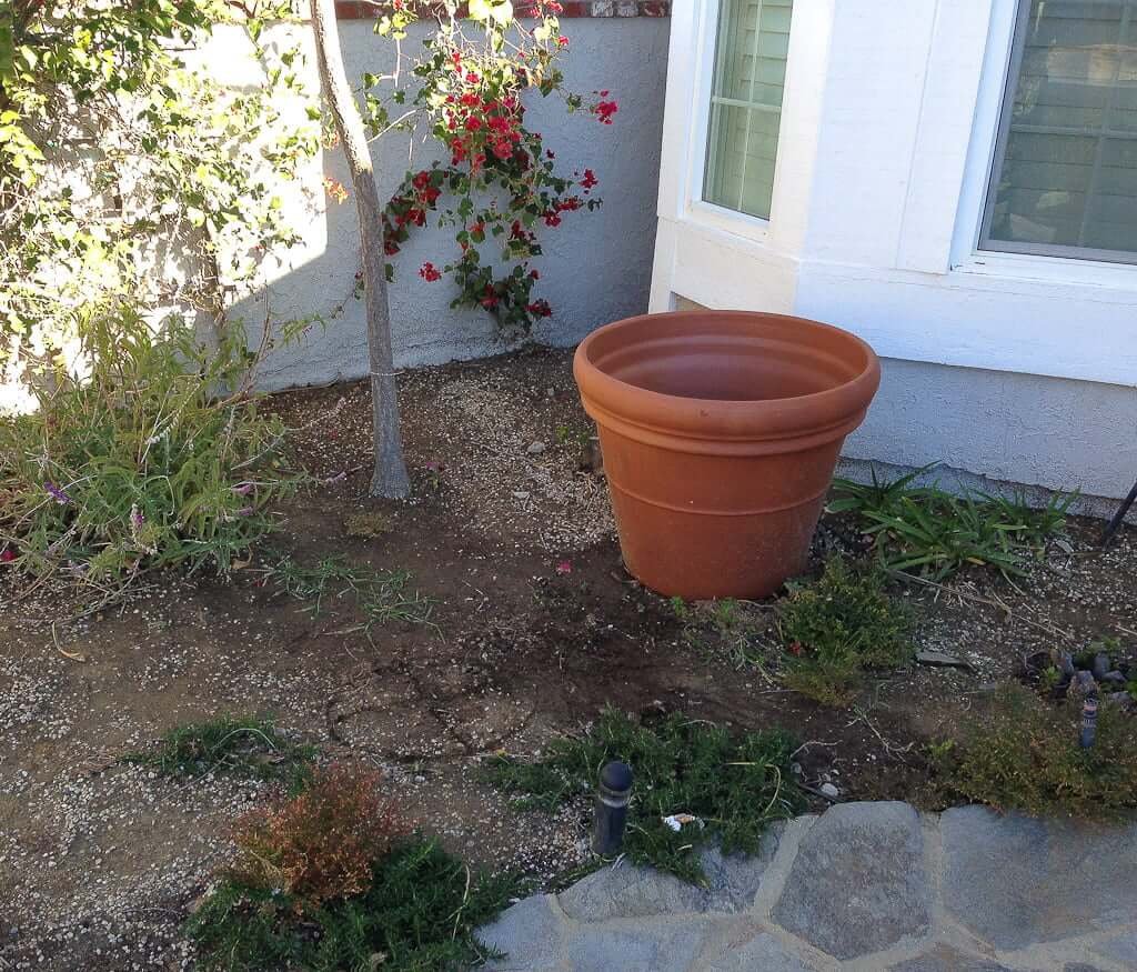 empty terra cotta pot with x on ground