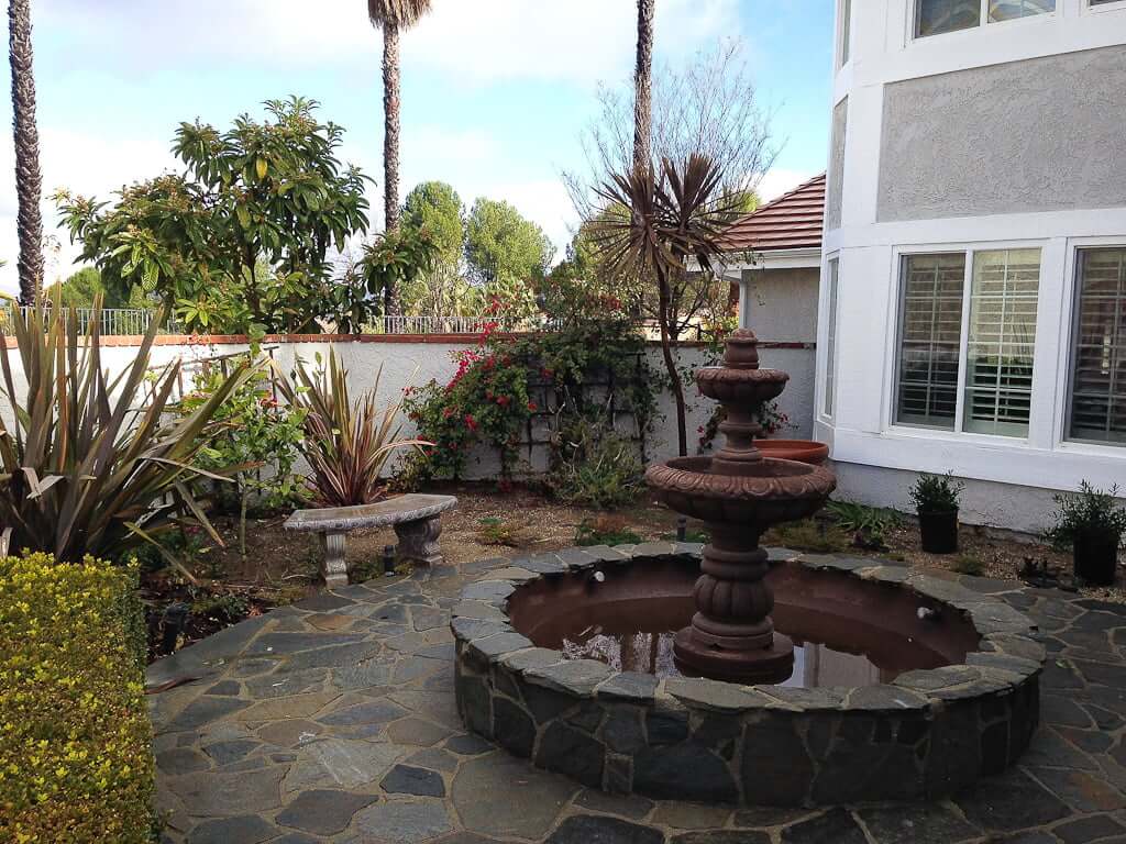 tiered fountain in courtyard patio in front of a house