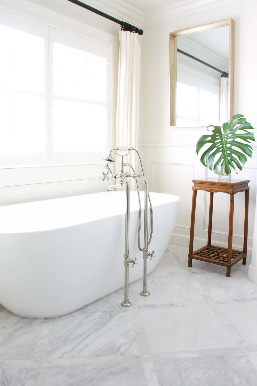 freestanding tub in master bathroom, renovated with marble tile