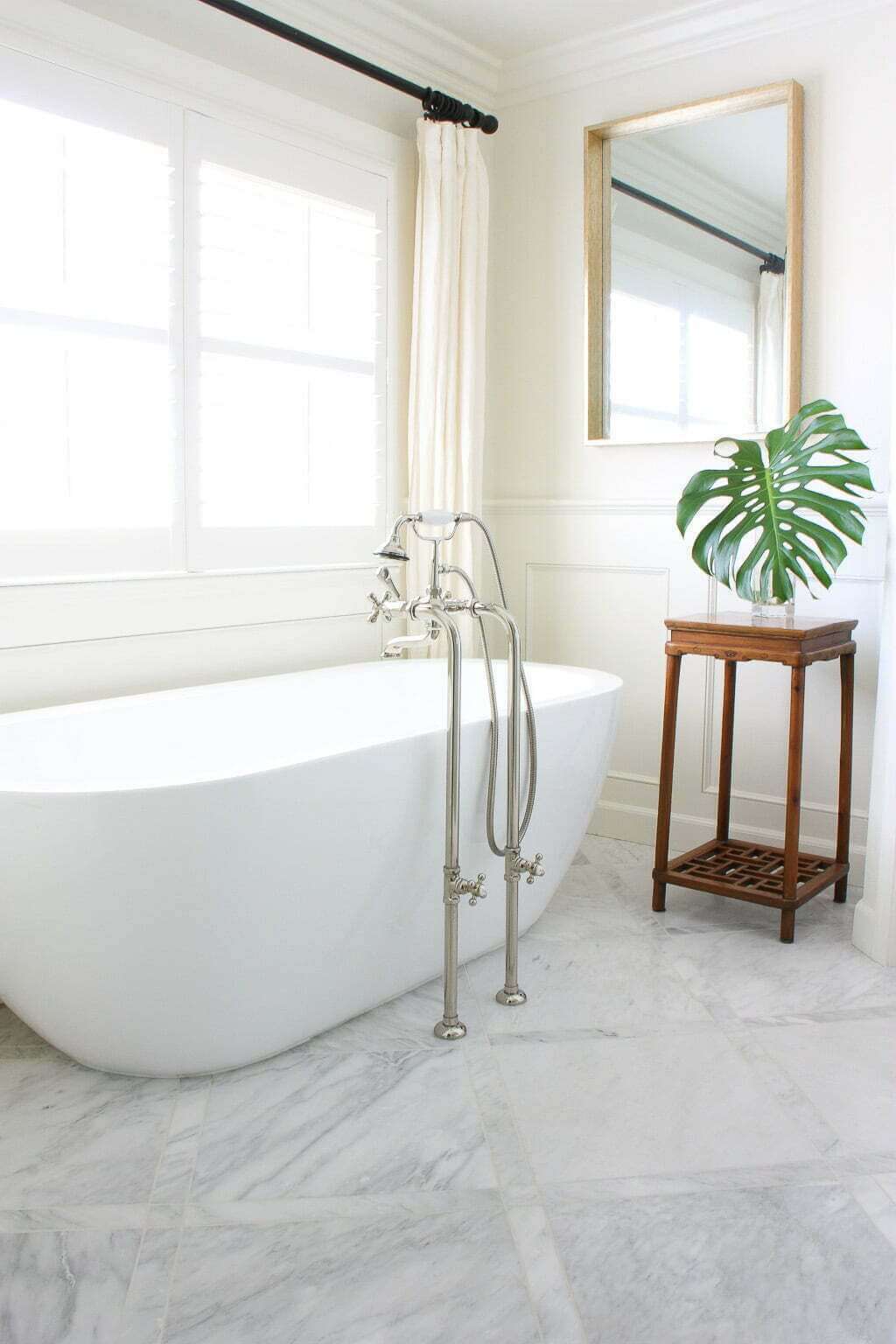 freestanding tub in bathroom with marble floor tiles
