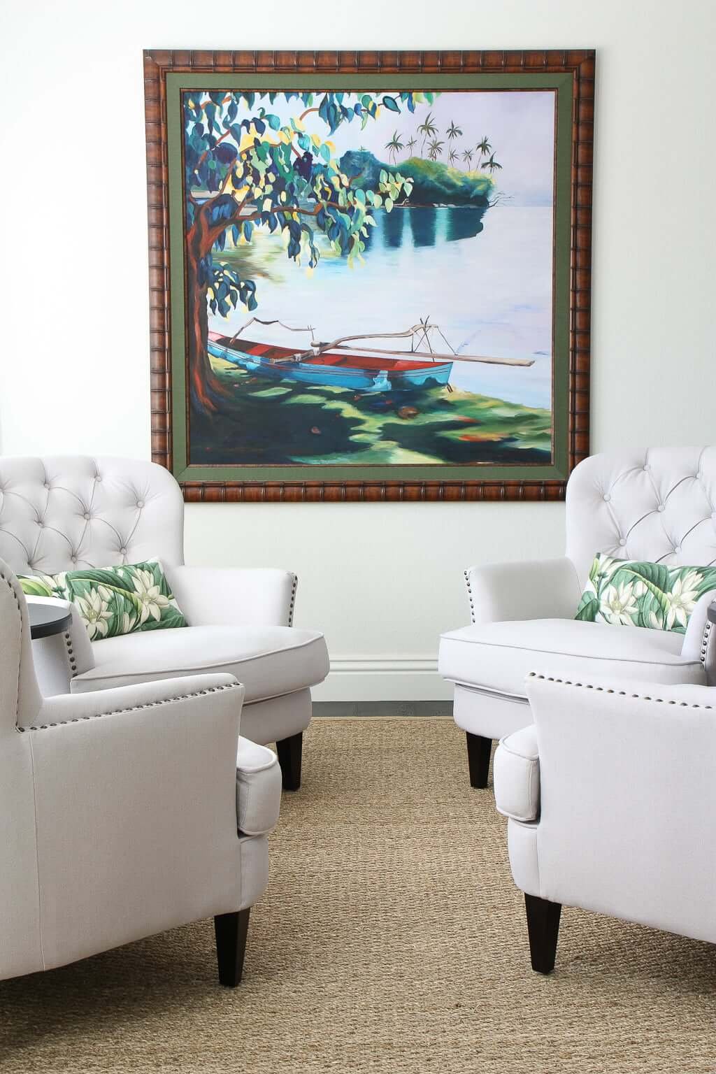 four armchairs facing each other, with tropical artwork on wall in background