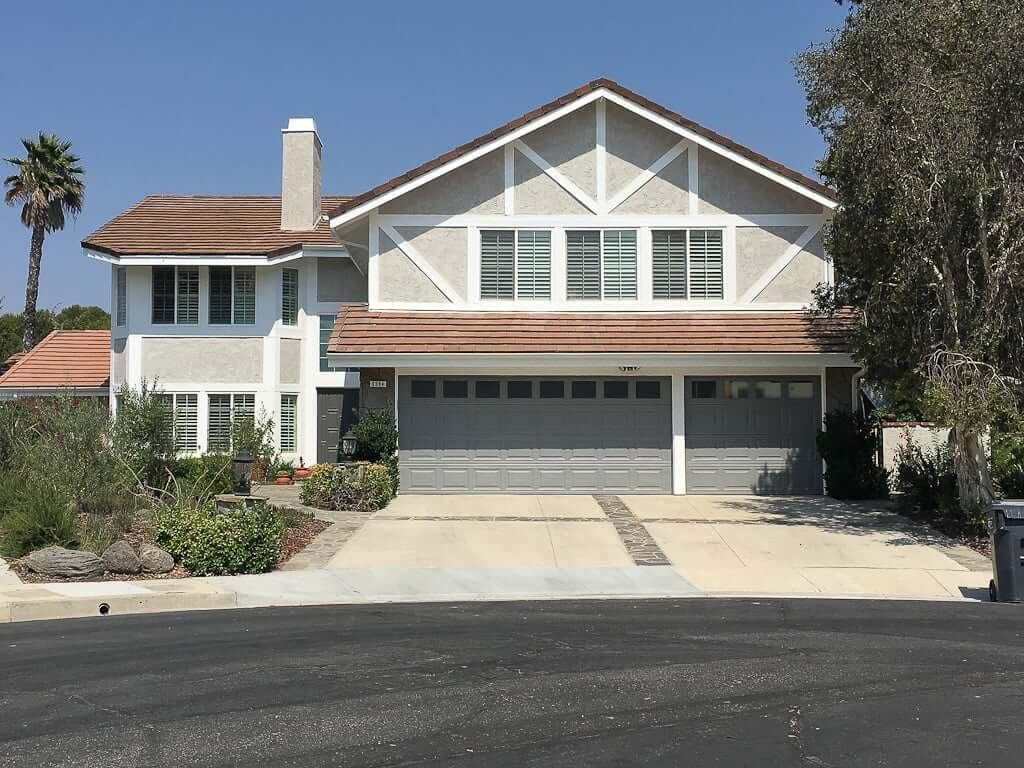 house painted with grey garage doors white trim and light grey stucco