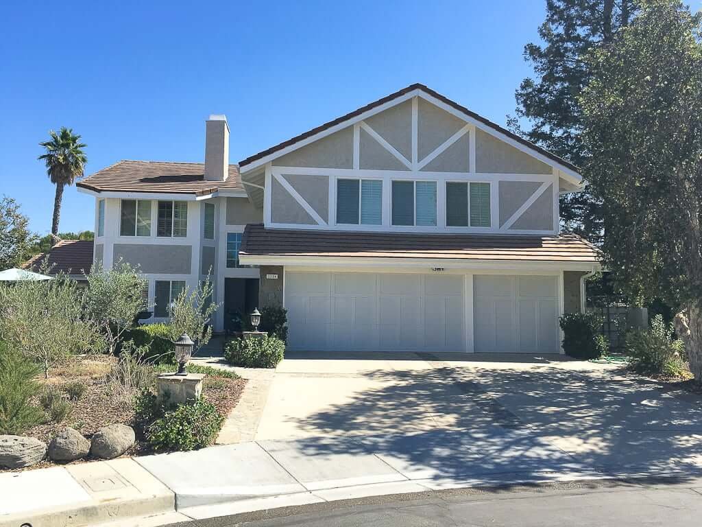 front house view with white trim white garage door and grey stucco