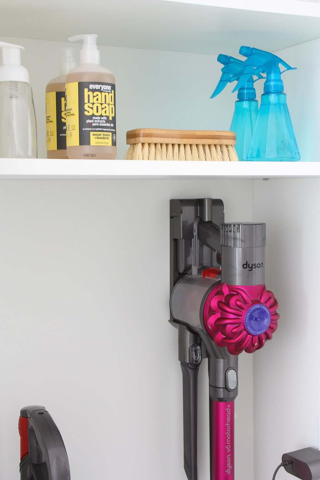 natural cleaning products on shelf, with vacuum below