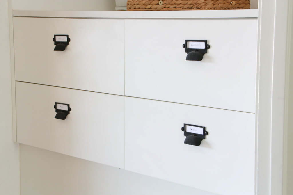 white mudroom storage drawers with black labeled pulls
