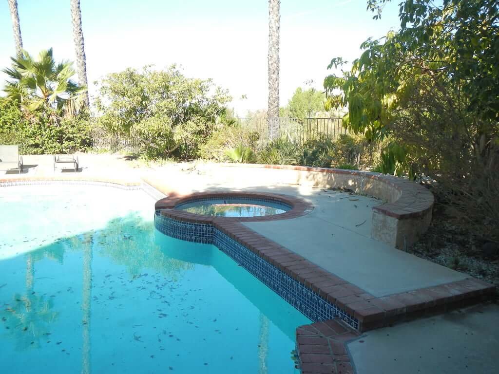 pool and jacuzzi with stucco seating and brick edging