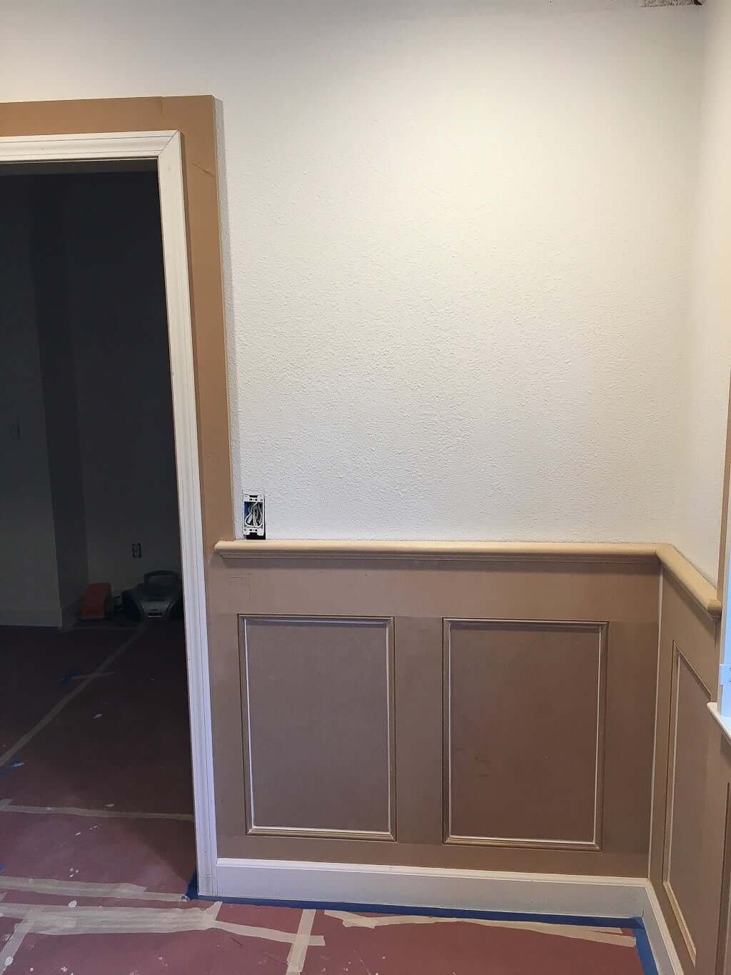 wainscoting and trim boards being installed around door