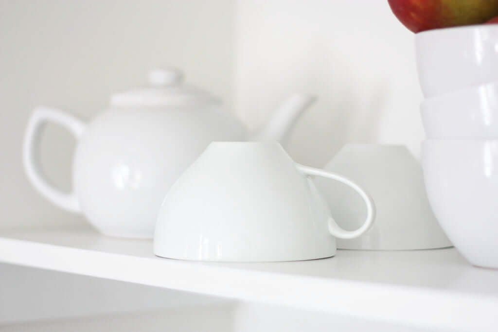 Teapot and cups on shelf