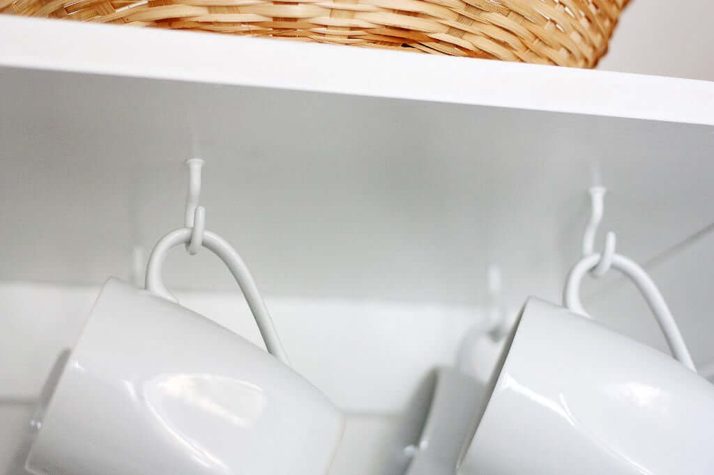 Coffee cups hanging under shelf