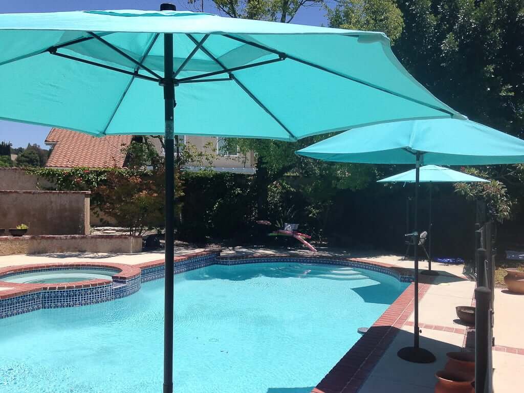 pool with blue umbrellas next to it