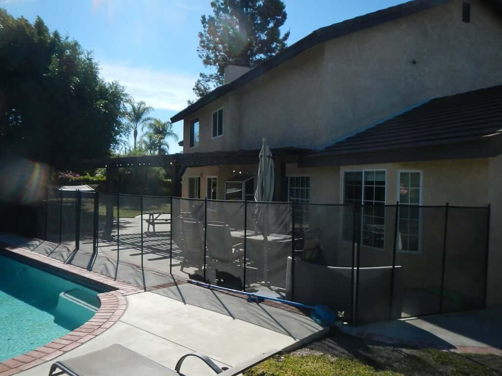 view of back house with pool fence and pool