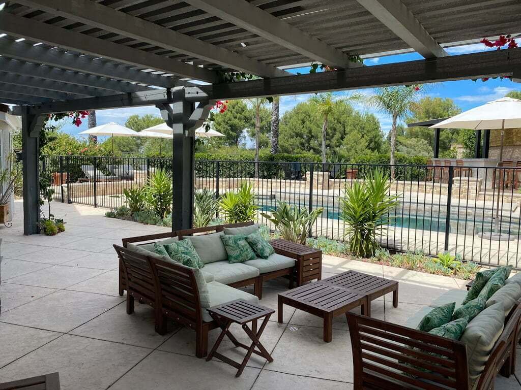 sitting area in backyard after makeover showing pool