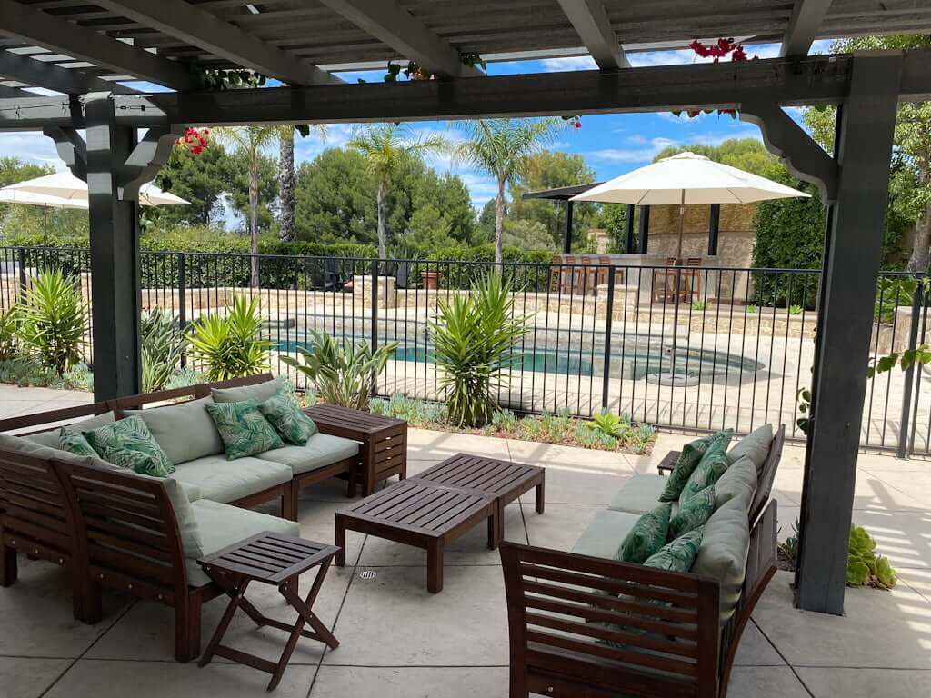sitting area after with wood furniture pool fence and pool