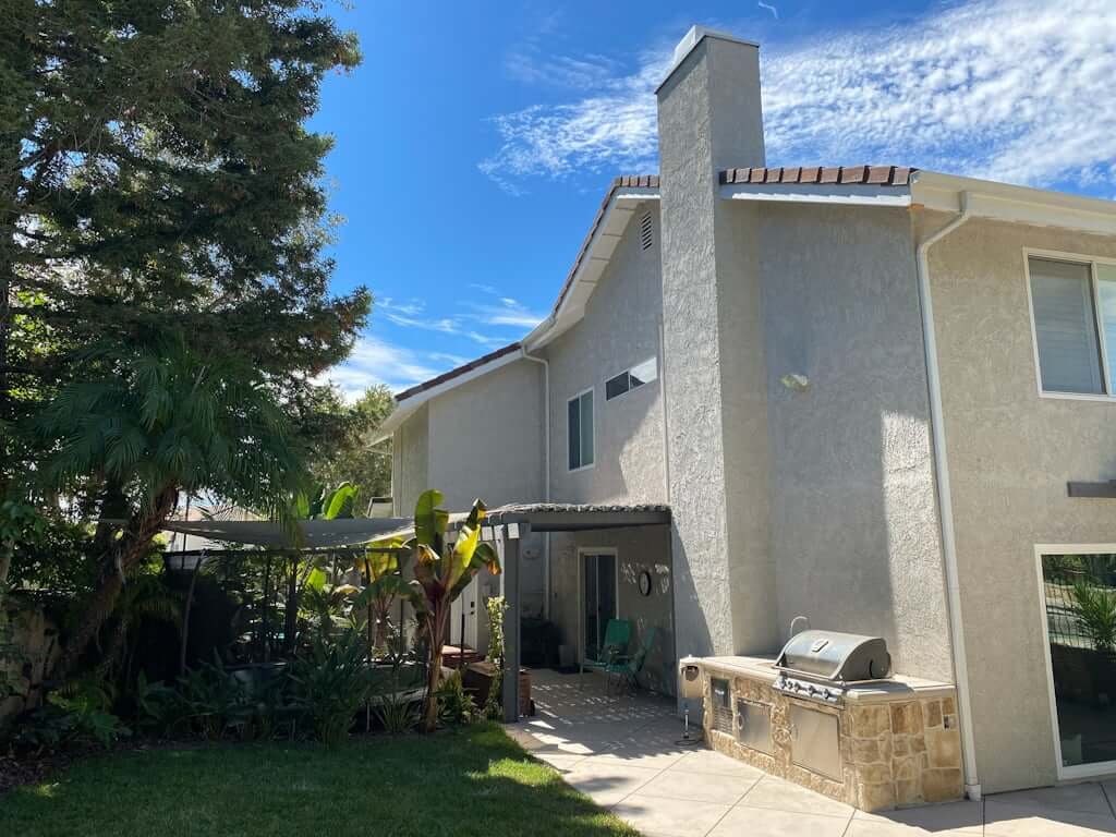 side yard of house with sunken trampoline and updated landscaping