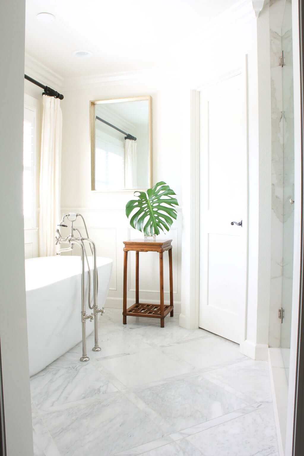 freestanding tub in bathroom with marble floor and double shower