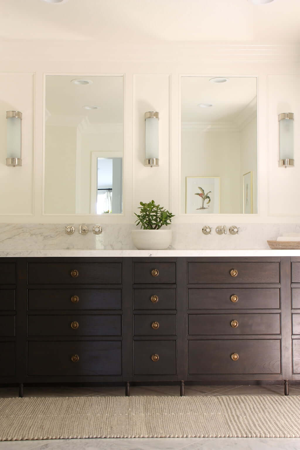 master bathroom double vanity, wood with marble countertop and brass ring pulls, wall-mounted faucet and wall sconces