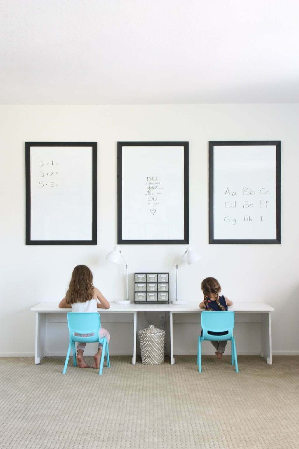 two children at IKEA homeschool desk with three minimalist dry erase boards above