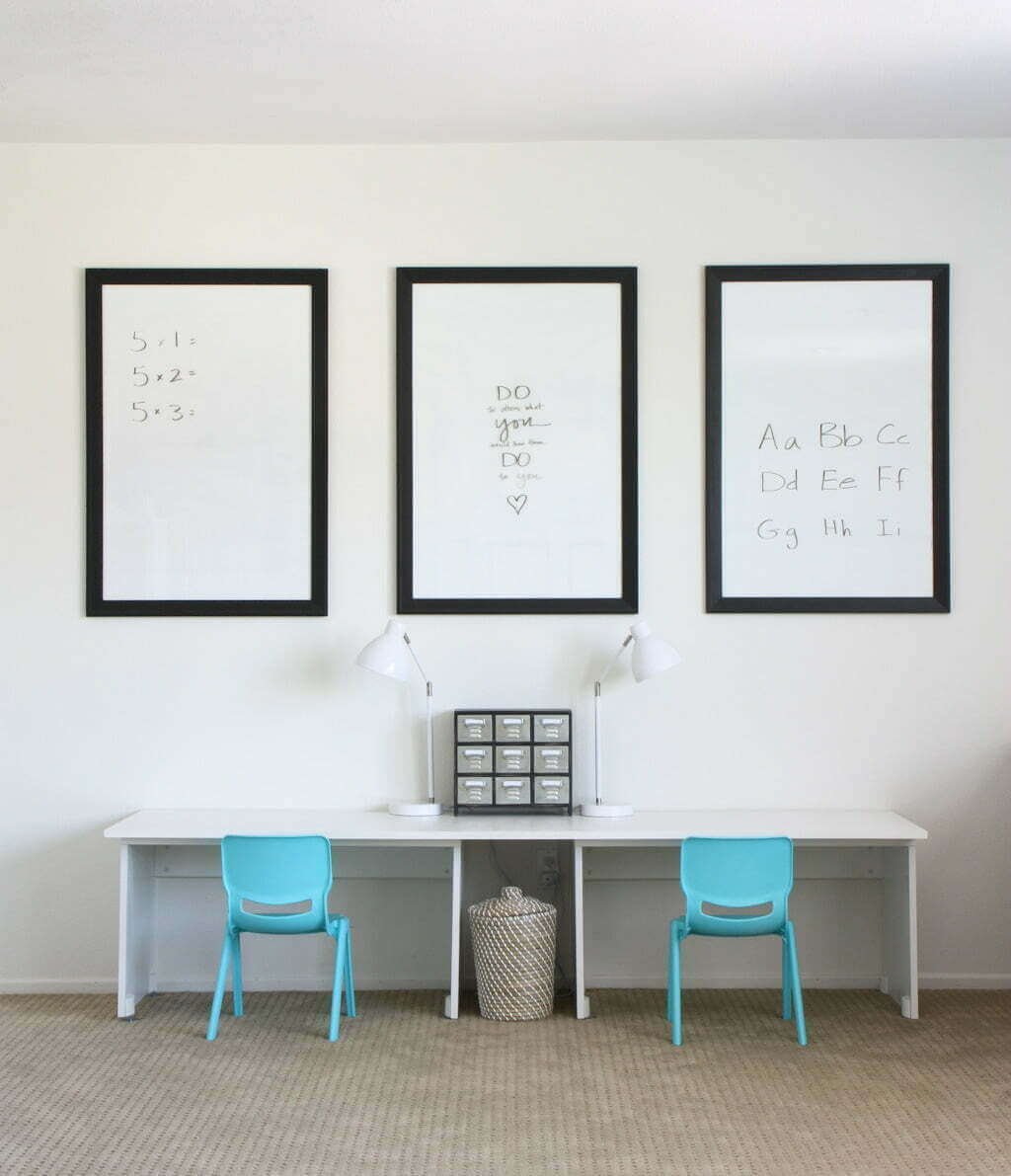 IKEA homeschool room with two chairs, IKEA desks, and three dry erase boards above