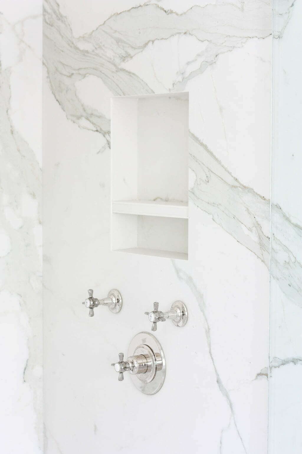 marble shower niche with polished nickel valves