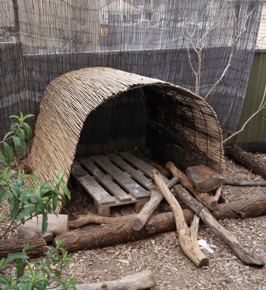 kids playhouse with thatch and logs