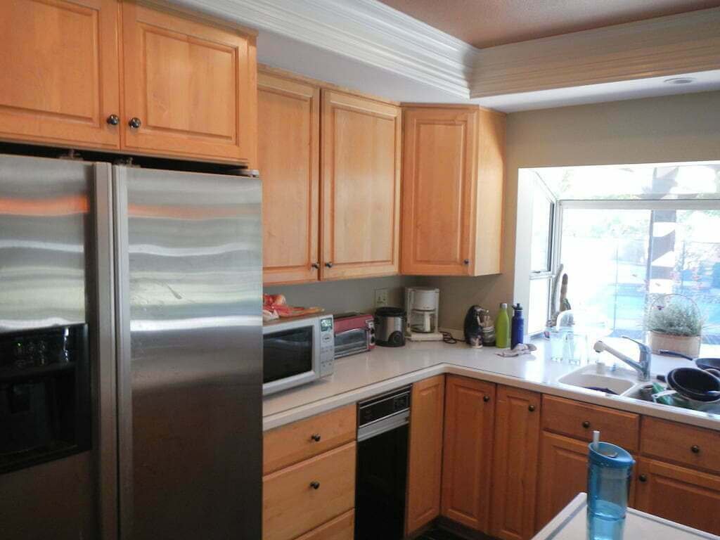 corner of kitchen before remodel, wood cabinet corner and fridge