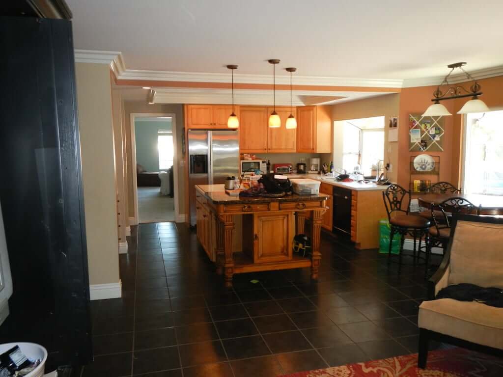 kitchen before remodel with black tile and wood cabinets