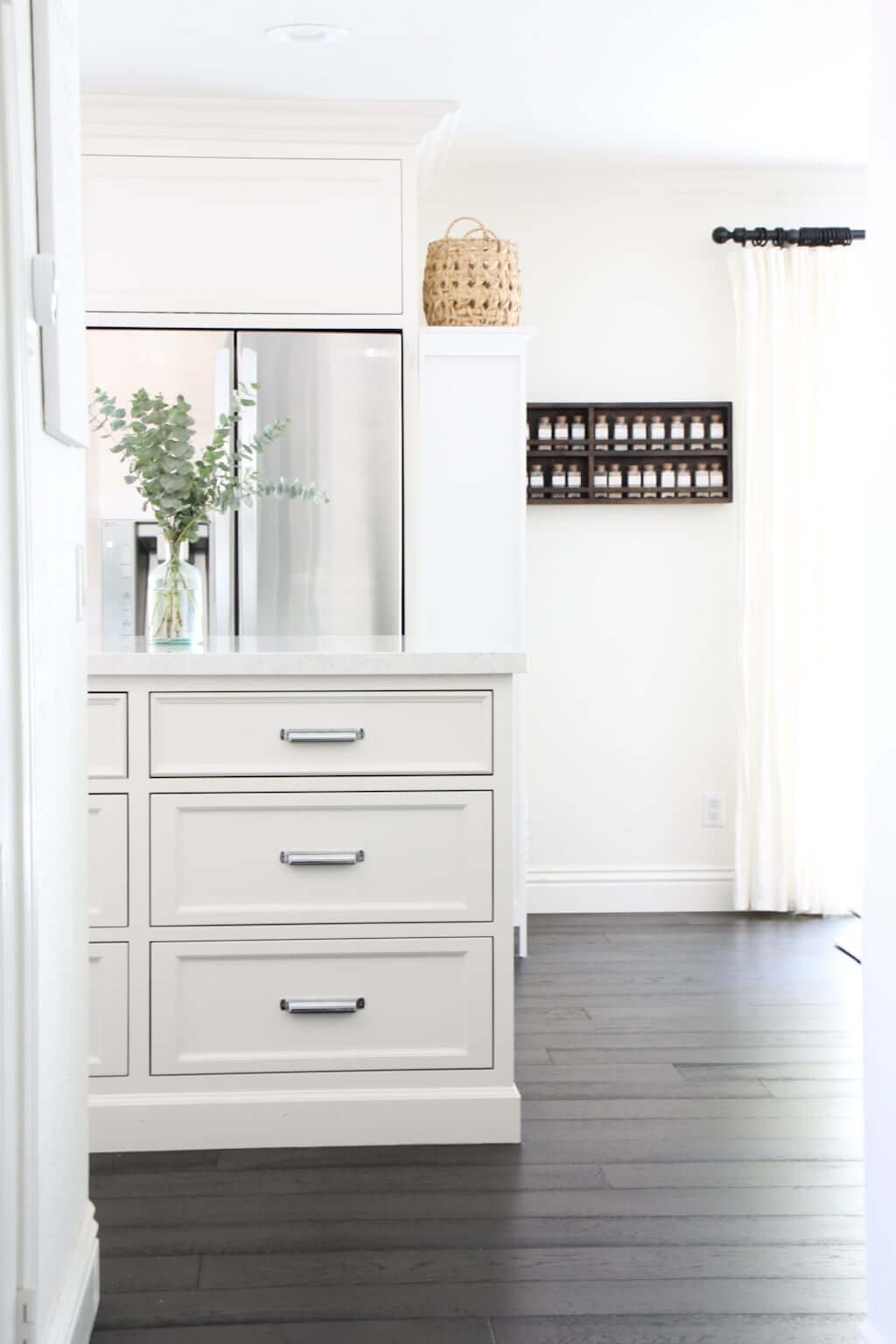 kitchen remodel after photo, white cabinets with fridge and dark hardwood flooring