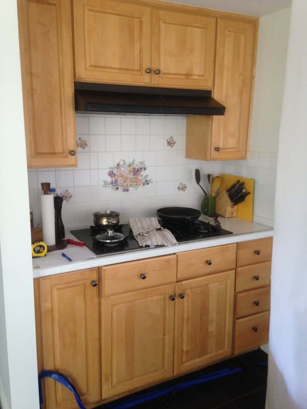 stove with tiled backsplash and wood cabinets