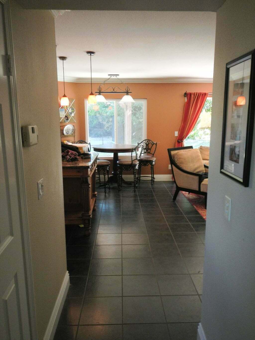 view towards kitchen and dining nook from hallway, black tiled floors