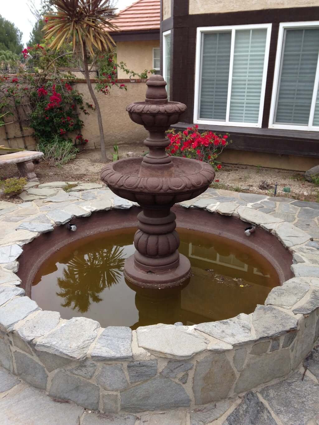 old brown fountain in basin with water