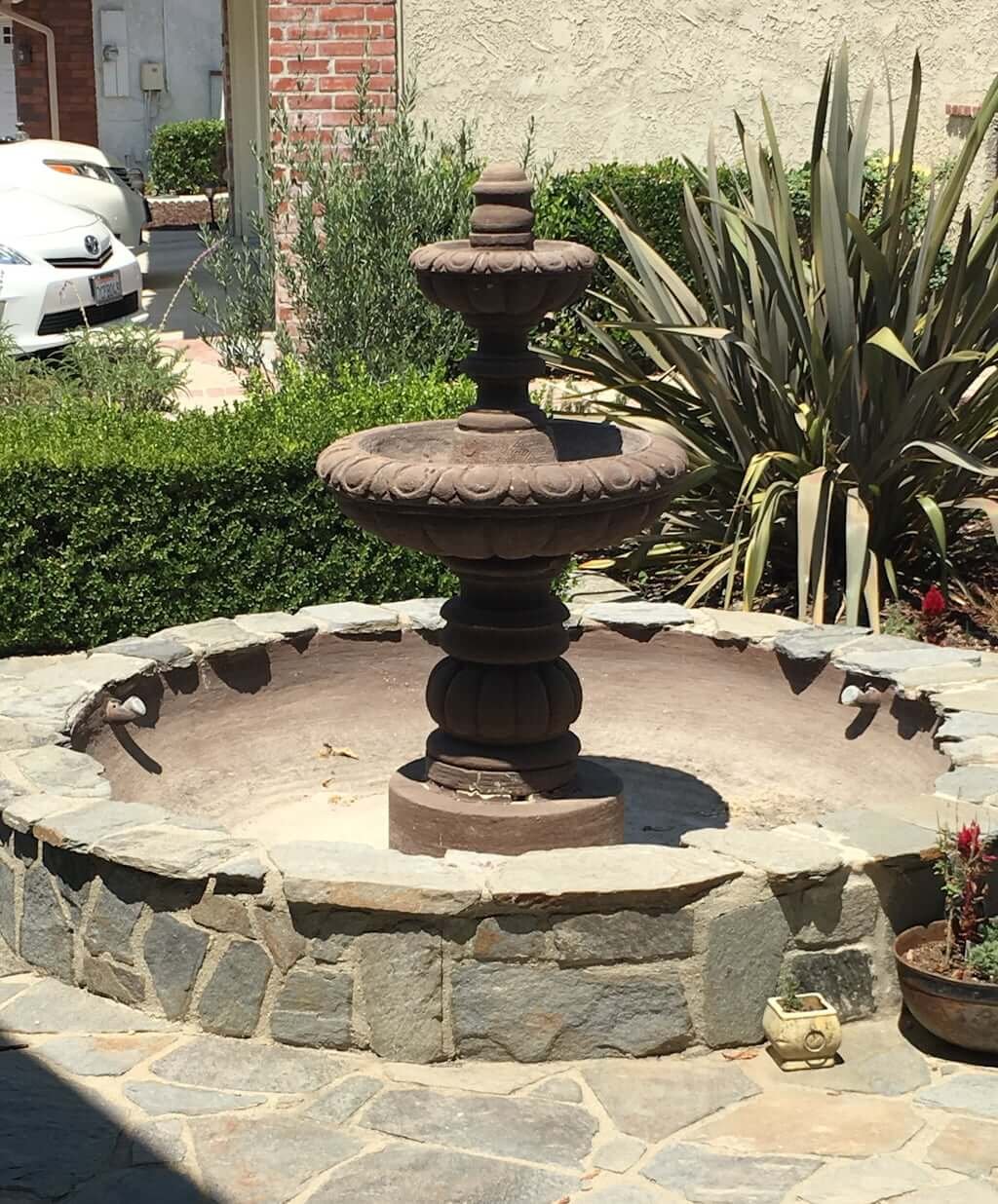 old brown fountain in empty water basin 