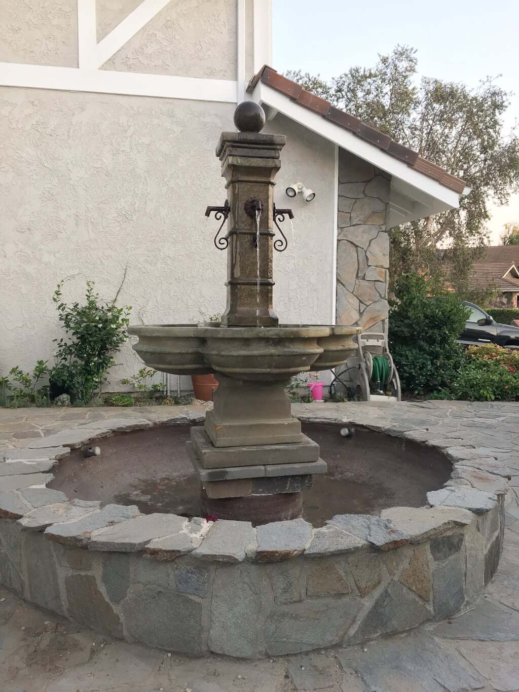 new pedestal fountain installed in basin with flagstone surround